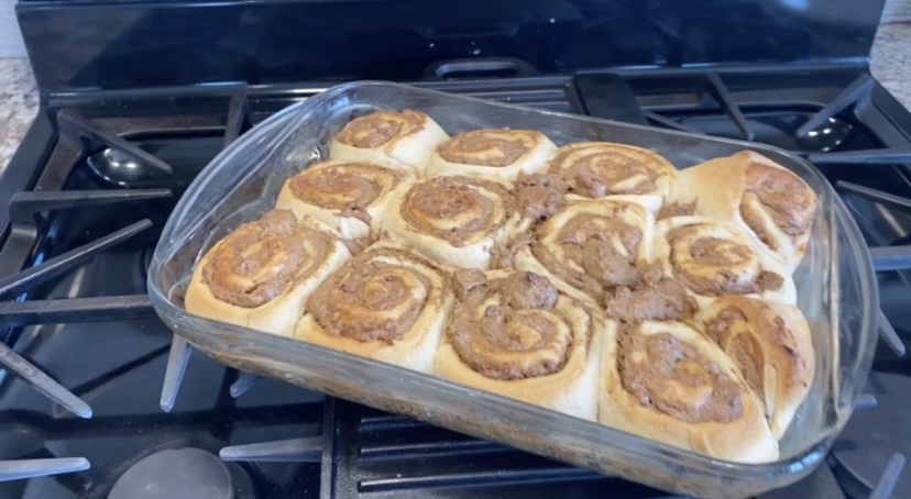 baked date cinnamon rolls in glass pan on stove top