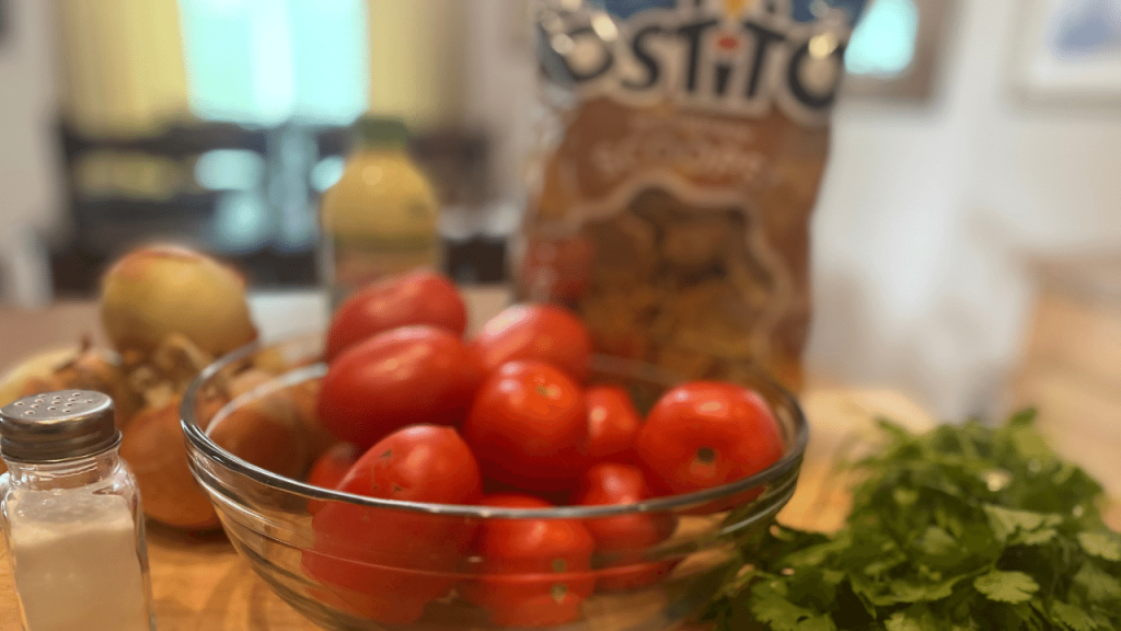 fresh salsa ingredients on cutting board, tomatoes, onions, cilantro, chips