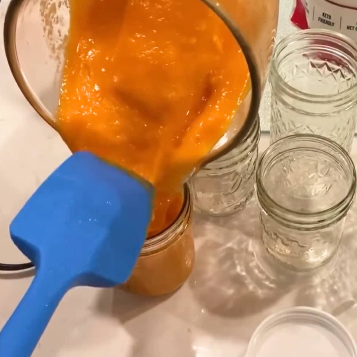 filling freezer safe mason jars with apricot freezer jam
