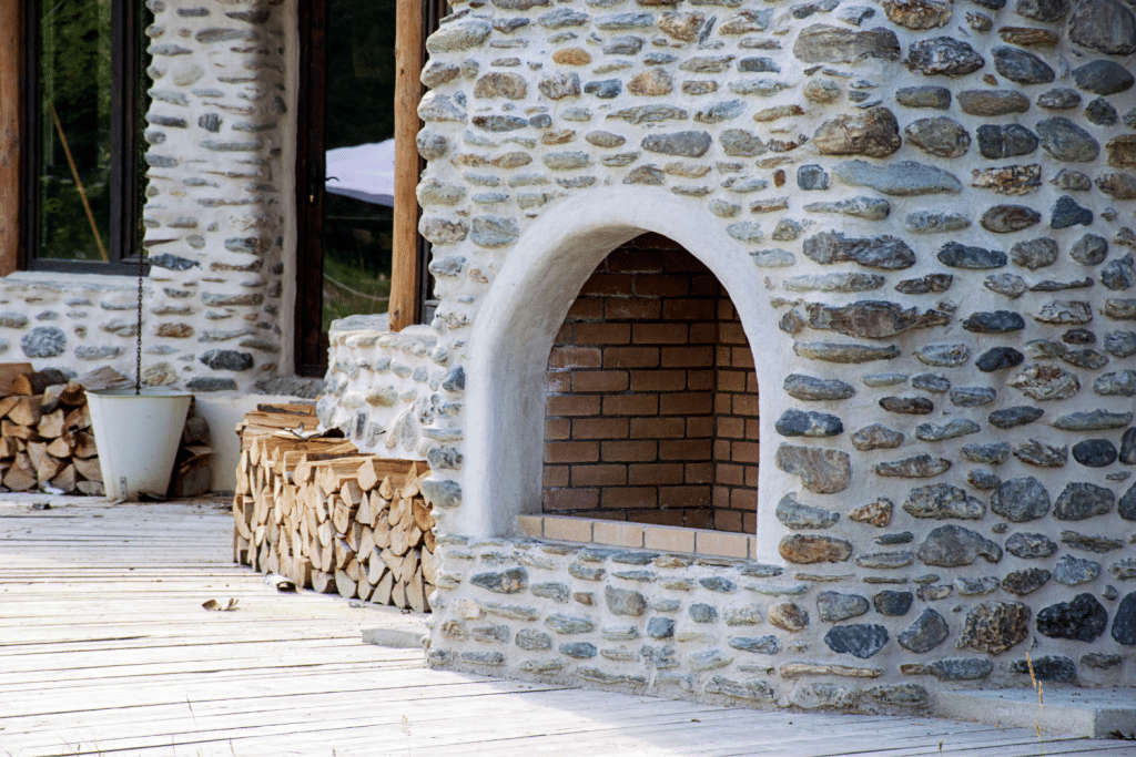 outside fireplace with wood chopped in piles 