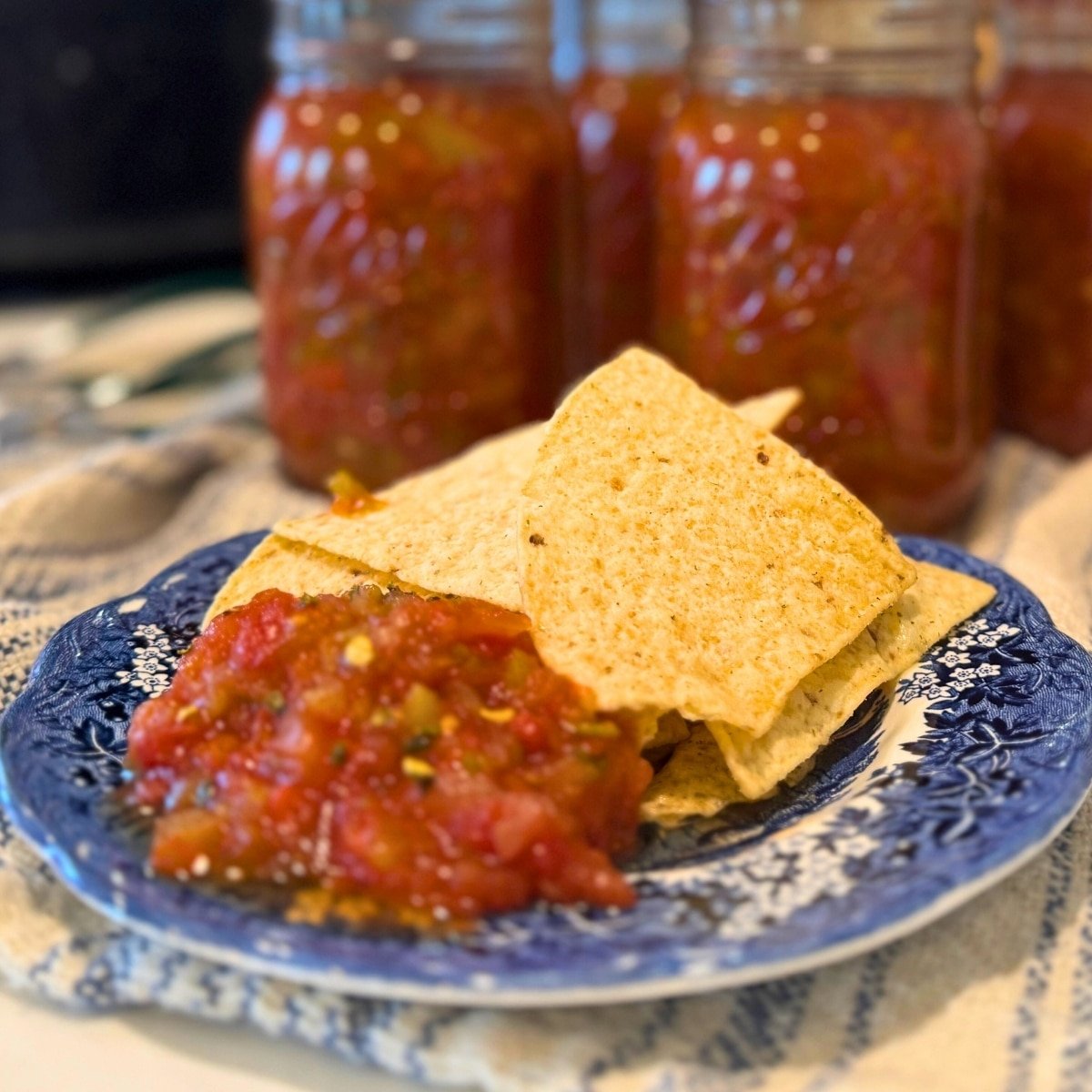 mild salsa canning recipe in jars and on plate with chips