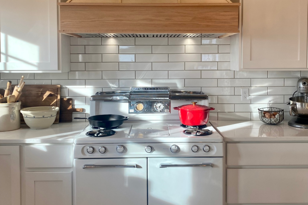 white stove with red dutch oven on top