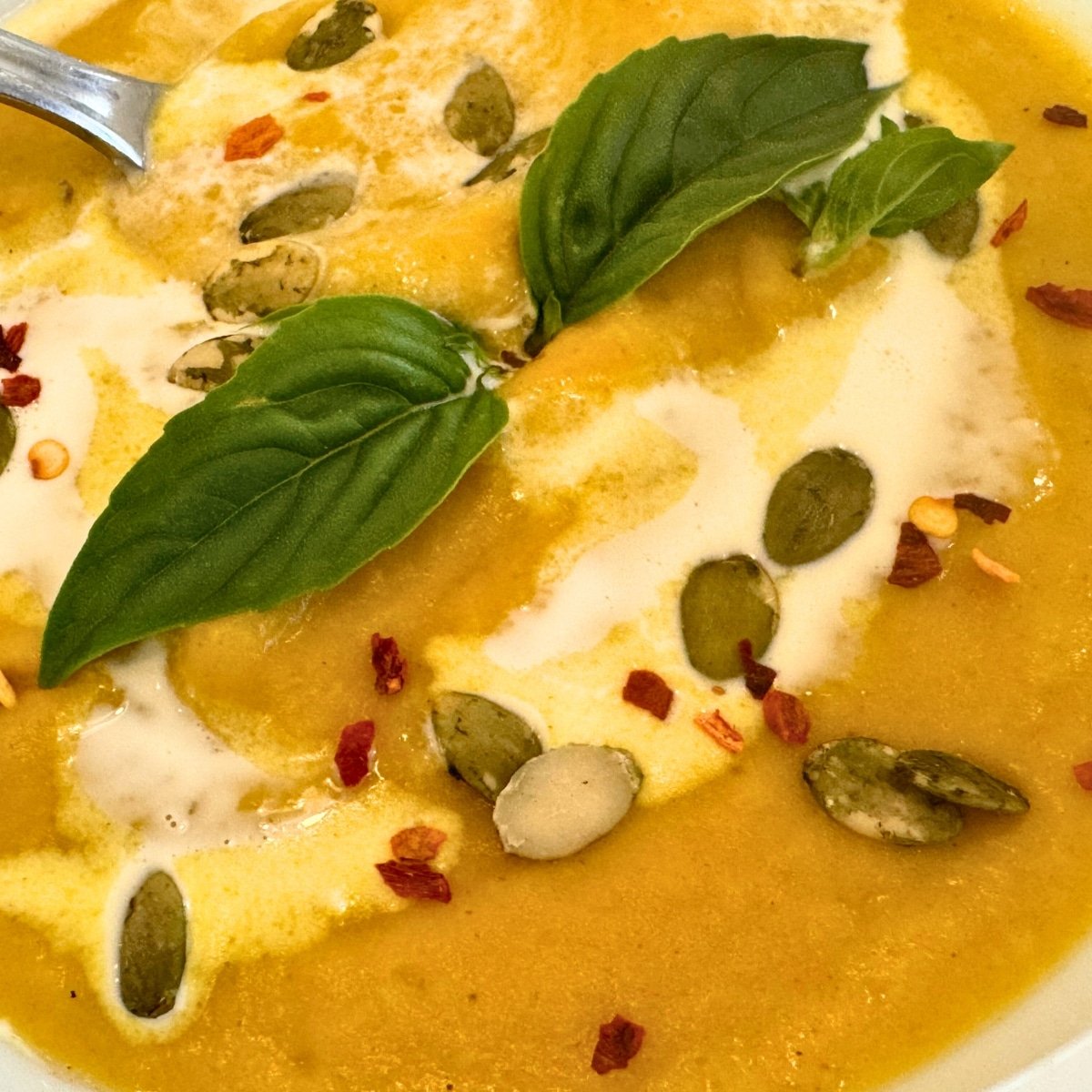 a bowl of butternut squash soup garnished in serving bowl