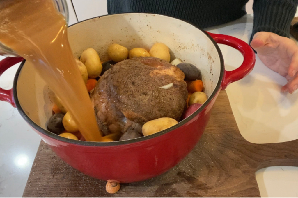 roast in pot pouring beef stock in before roasting
