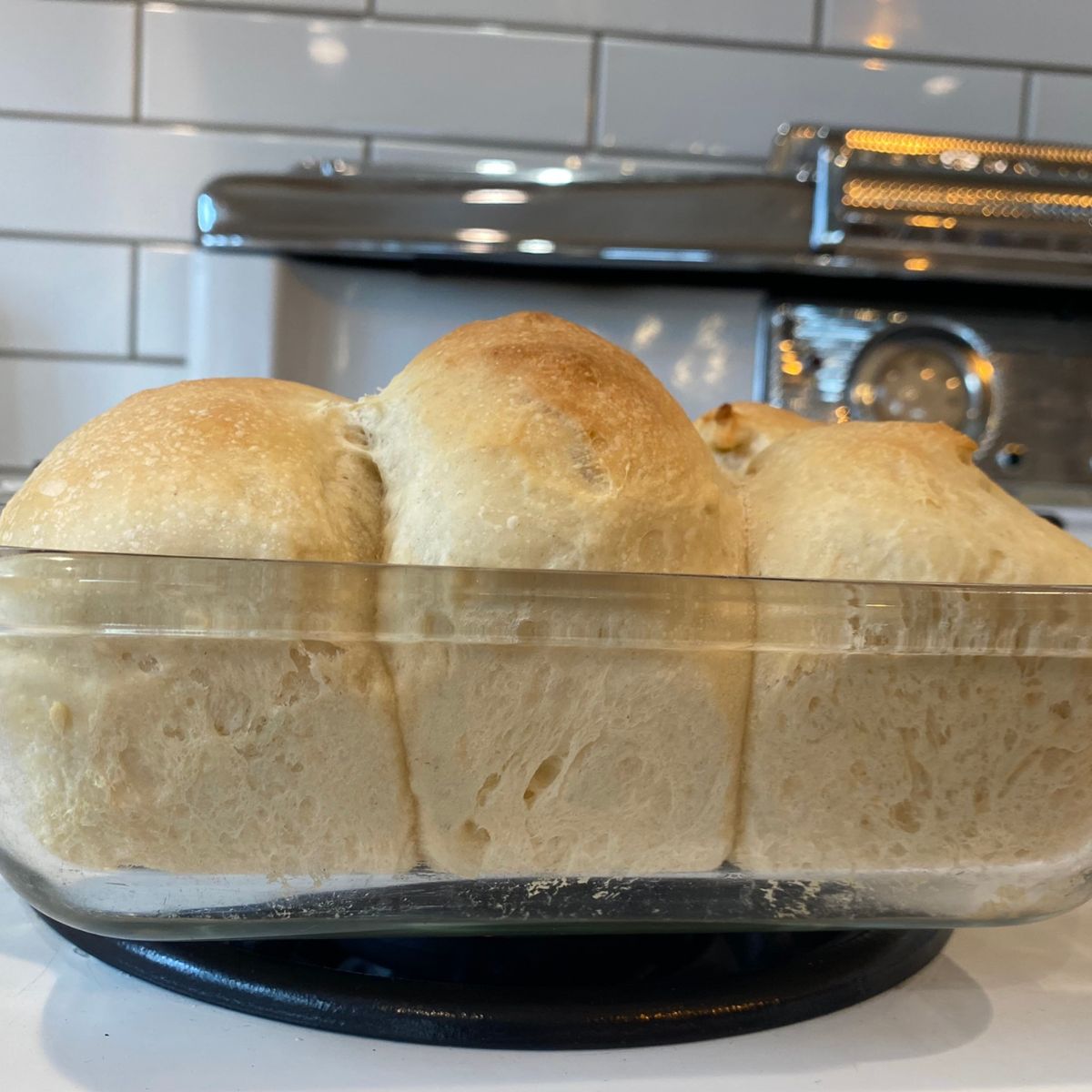 side view of soft sourdough rolls in pan on stove top