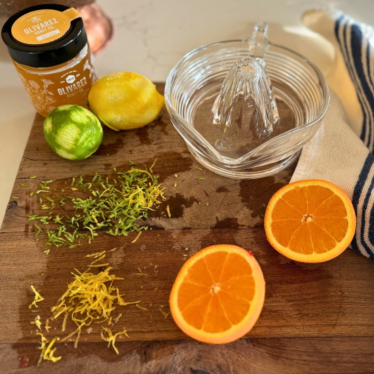 lime zest lemon zest, orange for juice and honey on cutting board