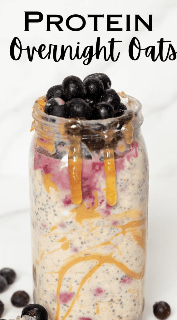 Protein overnight oats in jar overflowing with blueberries and drizzled honey by FarmhouseHarvest.net copywrite 2024