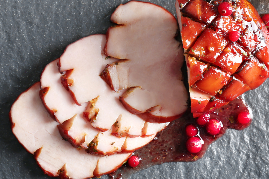 sliced glazed ham on cutting block