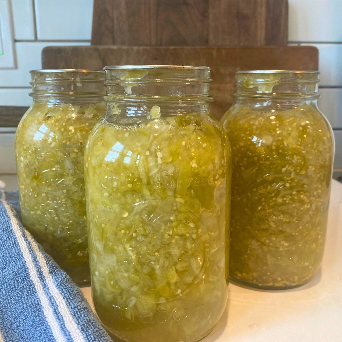 tomatillo salsa Verde canning recipe in canning jars on stove