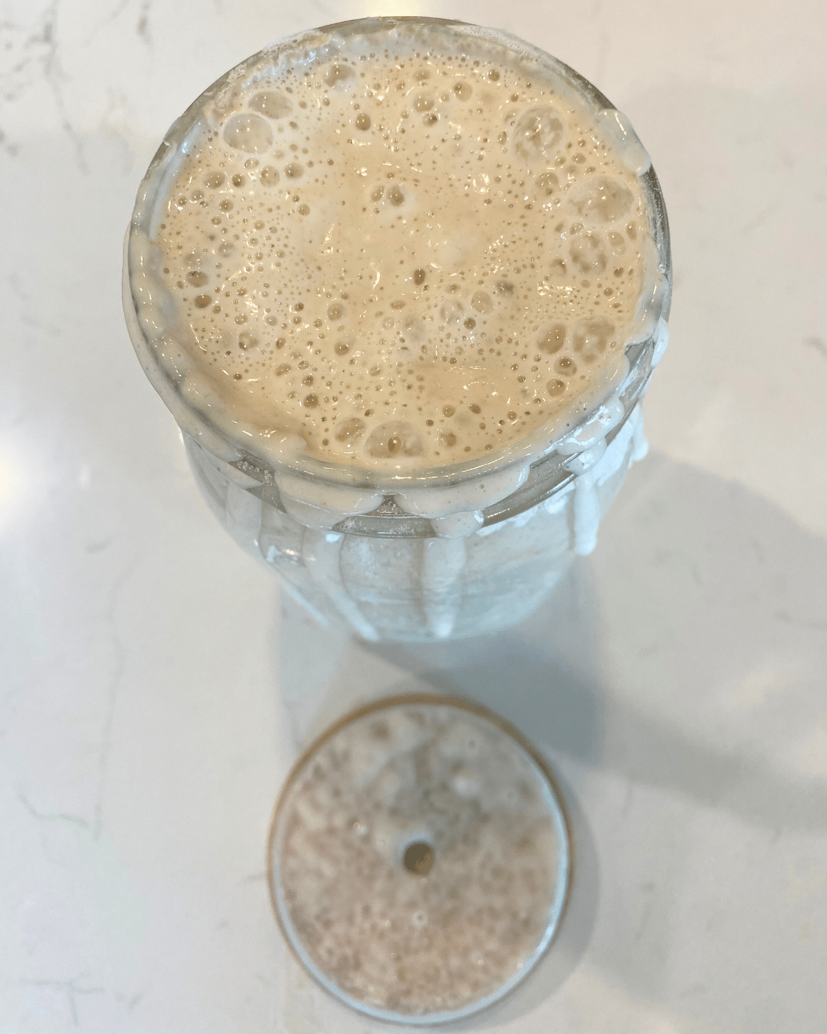 active bubbly sourdough starter in jar with lid
