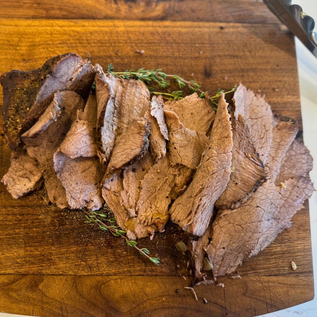 bottom round roast cooked well sliced on cutting board