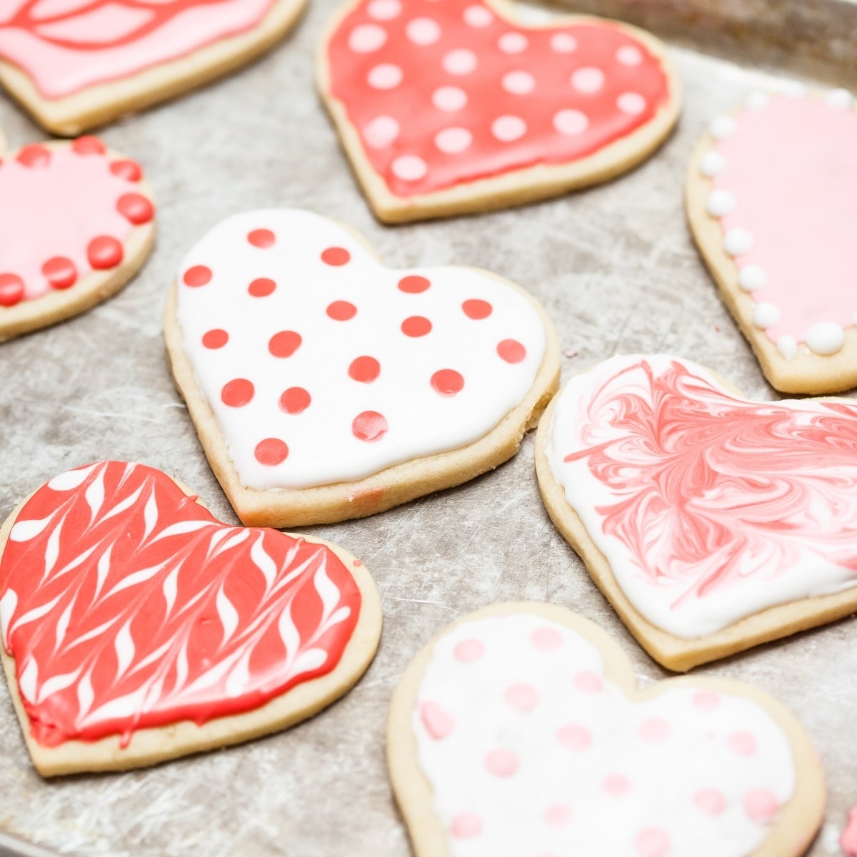 heart sugar cookies with sugar cookie icing on baking tray