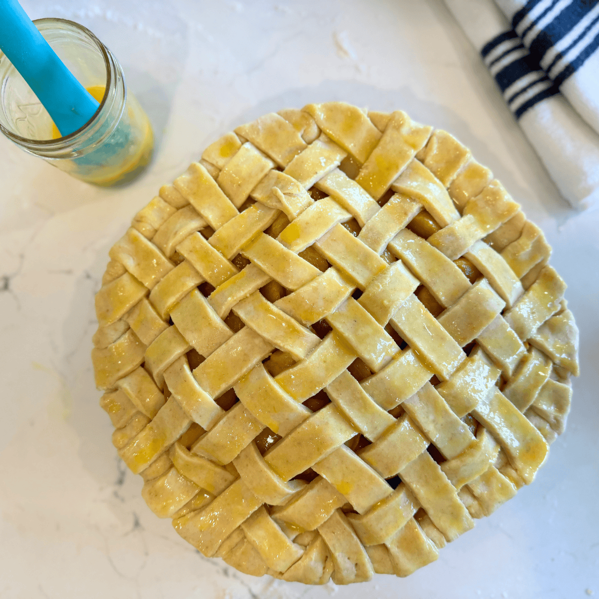 unbaked peach pie with egg was on lattice top