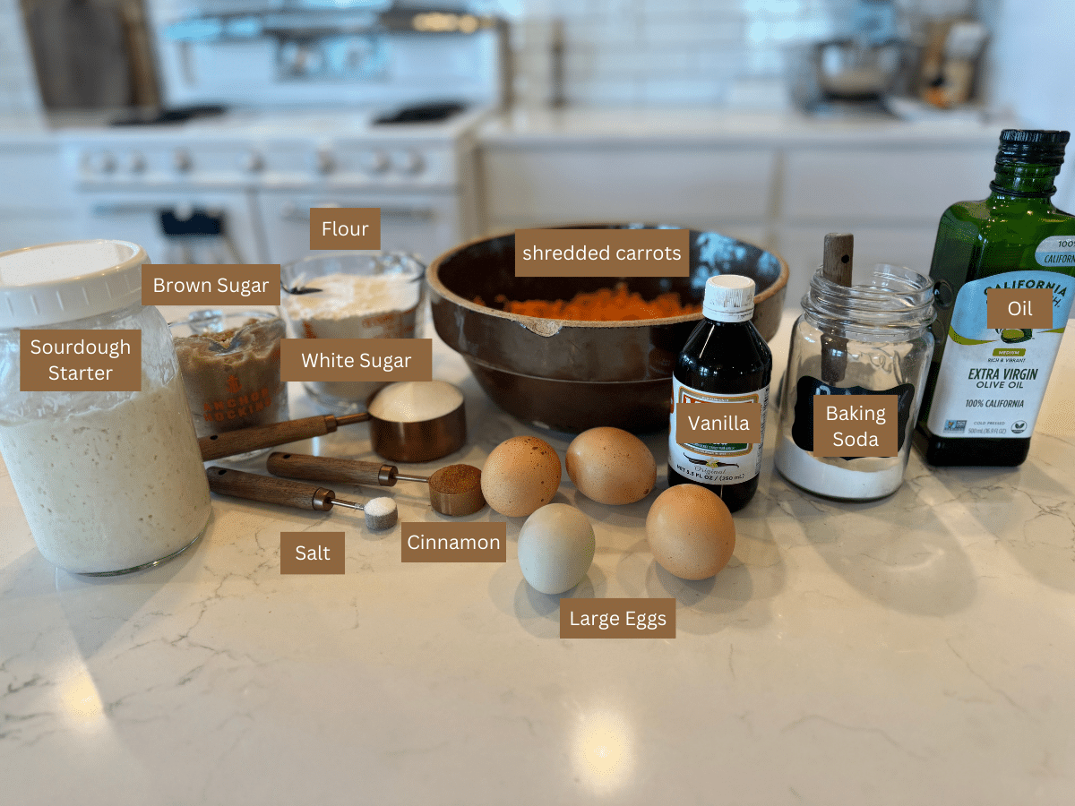 sourdough carrot cake ingredients: sourdough starter, brown sugar, white sugar, flour, eggs, salt, cinnamon, vanilla, baking soda, oil, and shredded carrots with text