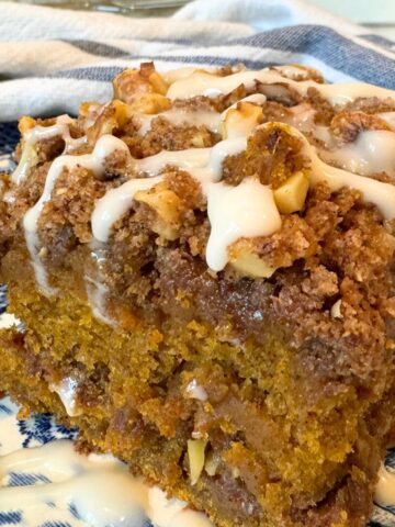 sourdough pumpkin streusel coffeecake with maple glaze on blue plate