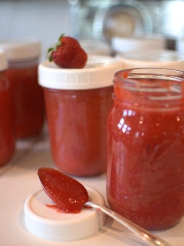 strawberry freezer jam in jars and on a spoon