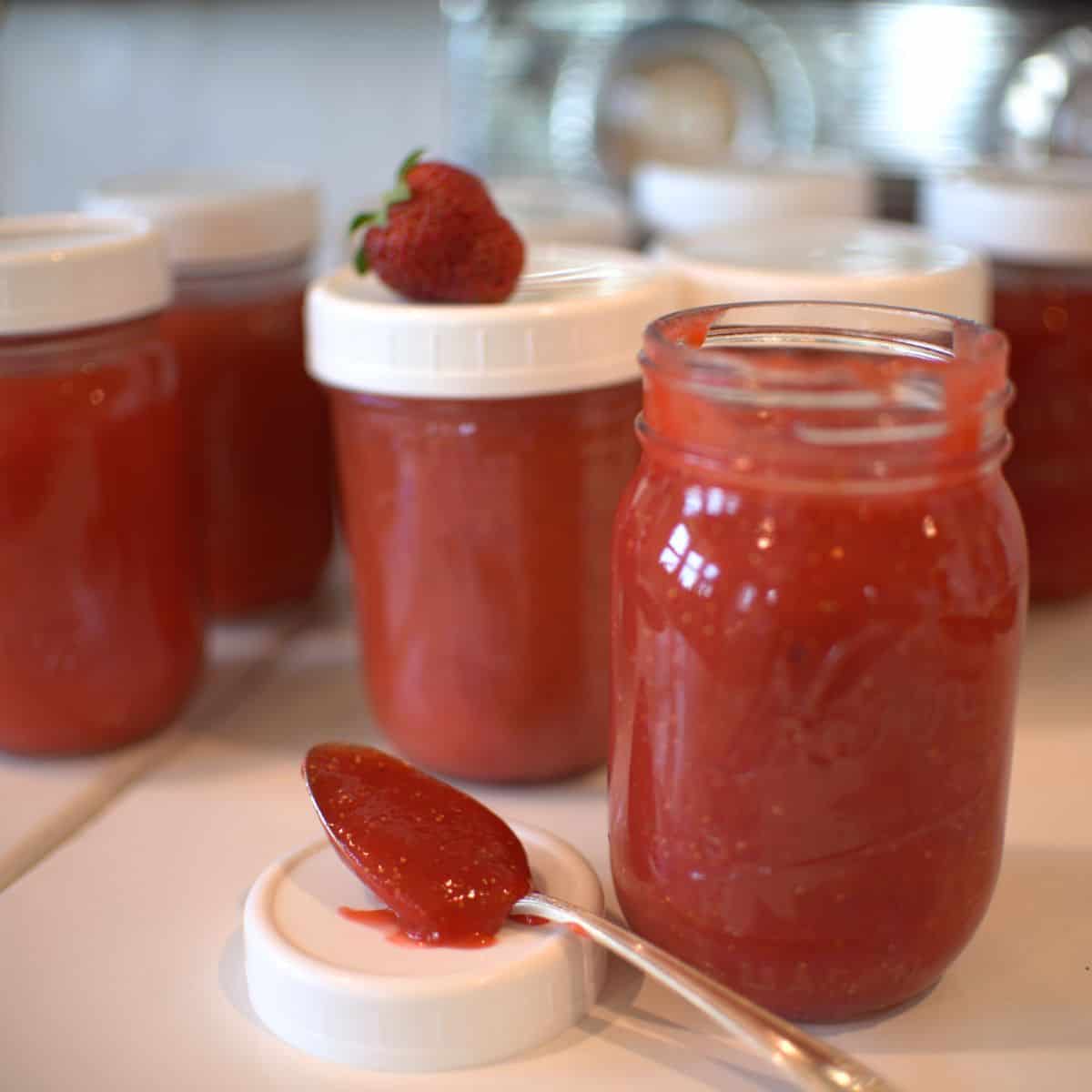 strawberry freezer jam in jars and on a spoon