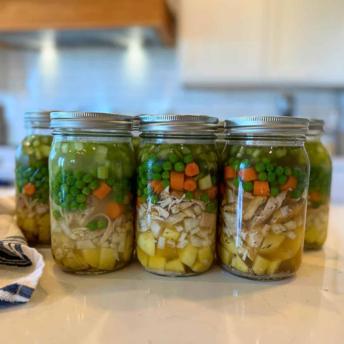 7 quart jars full of chicken pot pie filling ready to be processed in a pressure canner