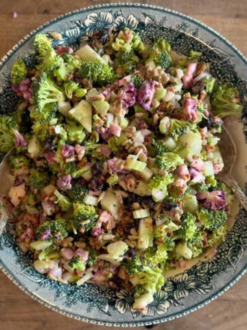 bacon croccoil salad in blue bowl on cutting board with serving spoons