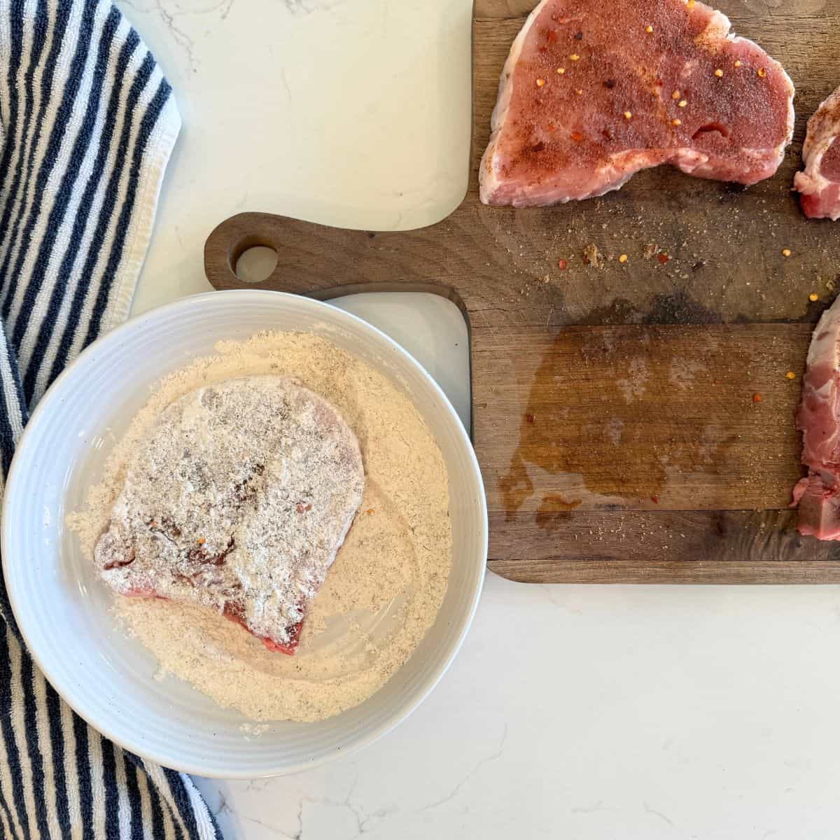 dredging seasoned pork chops in flour