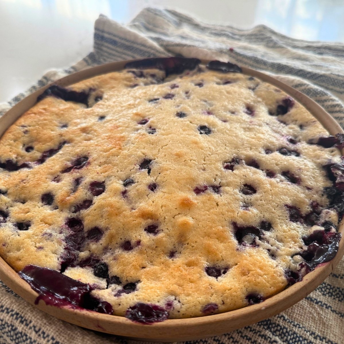 whole huckleberry cobbler right out of the oven cooling on kitchen towel