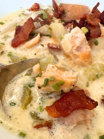 creamy fish chowder in bowl with spoon, enlarged to show texture