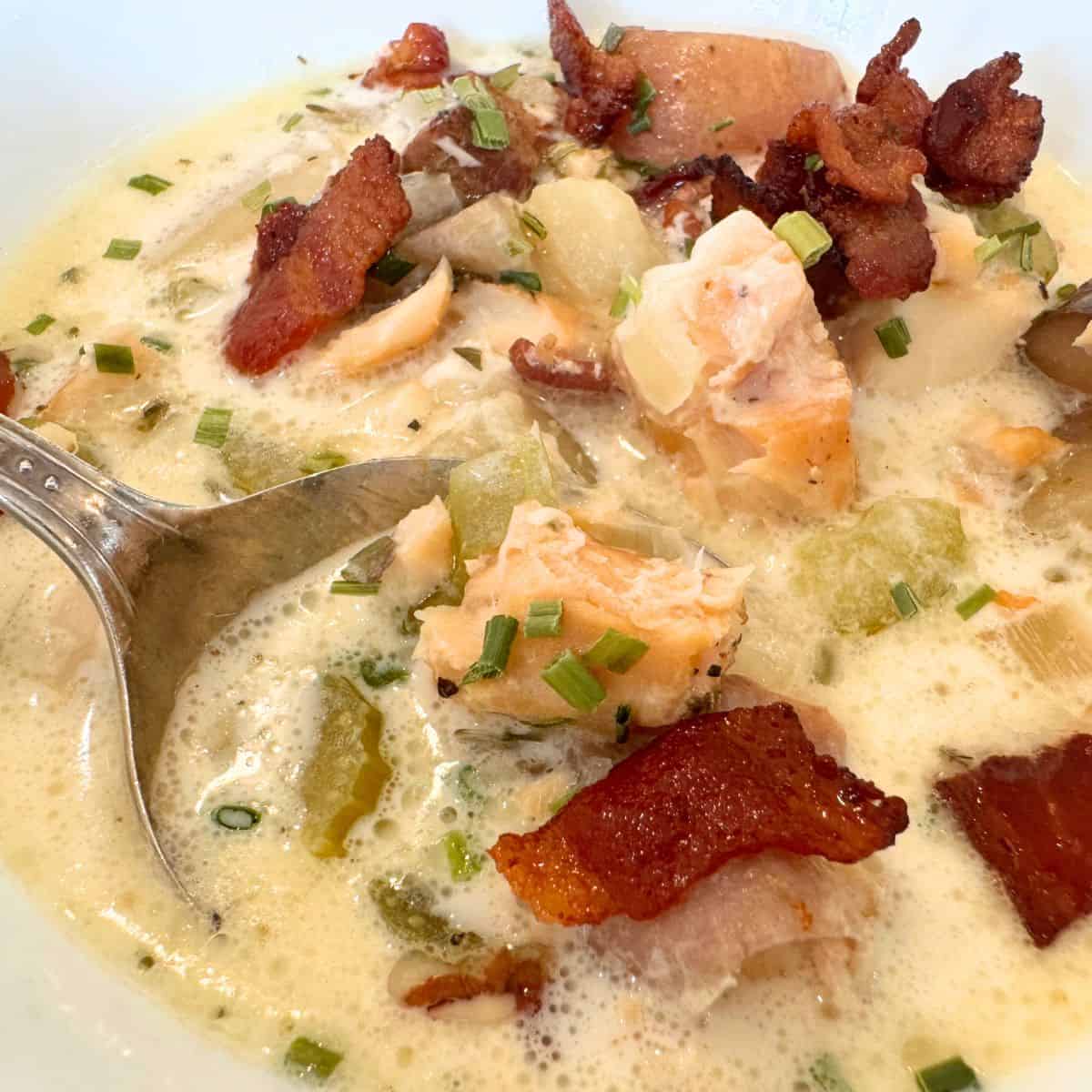 creamy fish chowder in bowl with spoon, enlarged to show texture