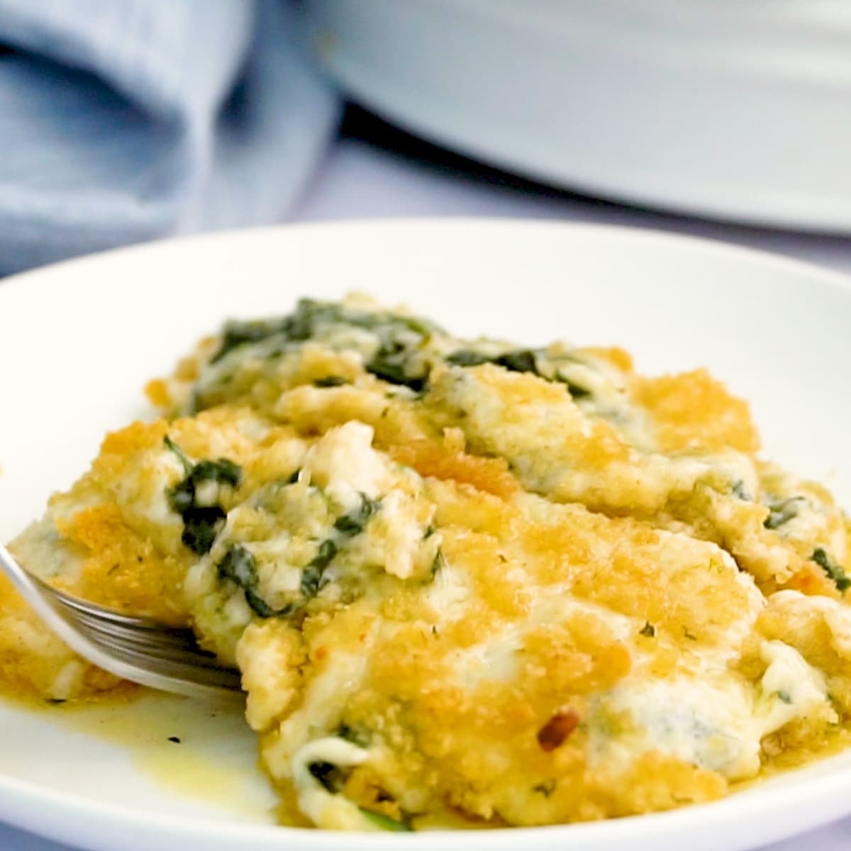 served creamed spinach on plate with fork taking a bite