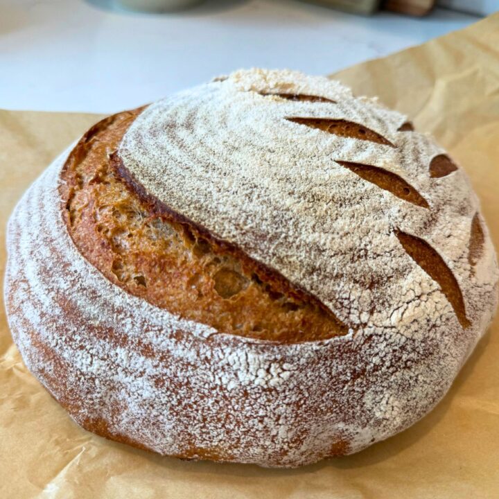 90% Einkorn sourdough bread recipe loaf cooling on counter on parchment paper