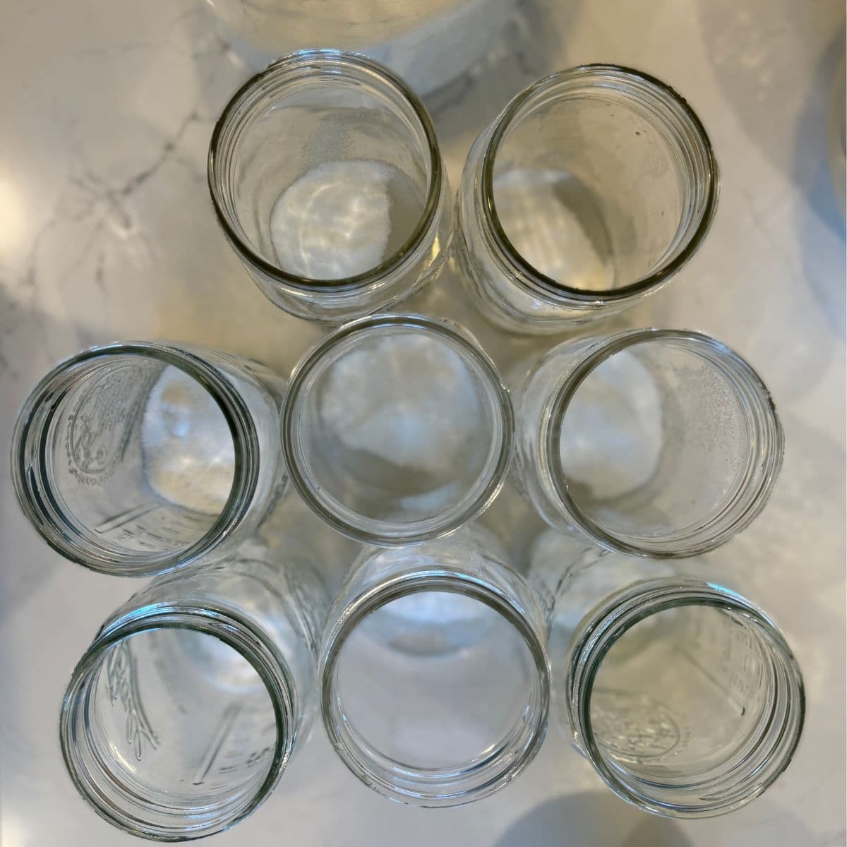 quart jars with sugar and lemon juice in the ready to get peaches loaded inside for canning