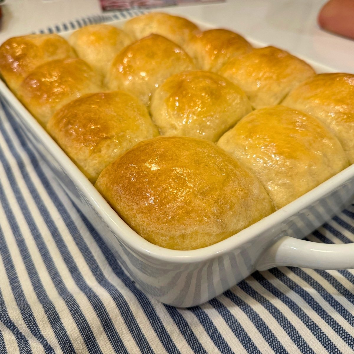 baked and buttered soft sourdough rolls in a 13x9 baking dish