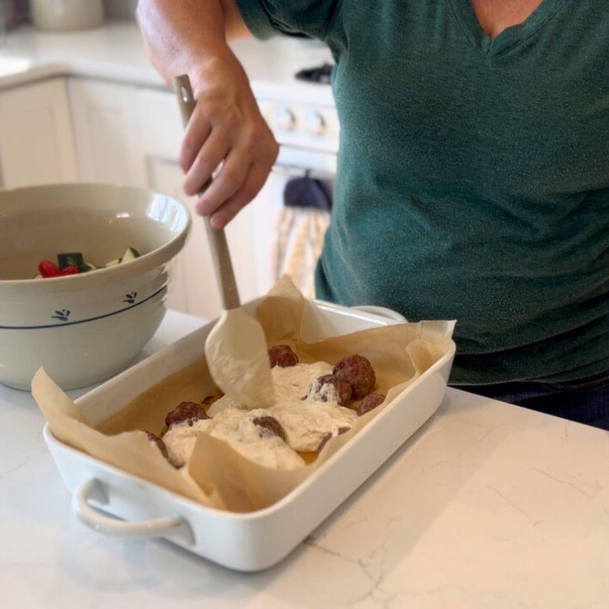 spreading sourdough starter mixture between the sausage meat balls