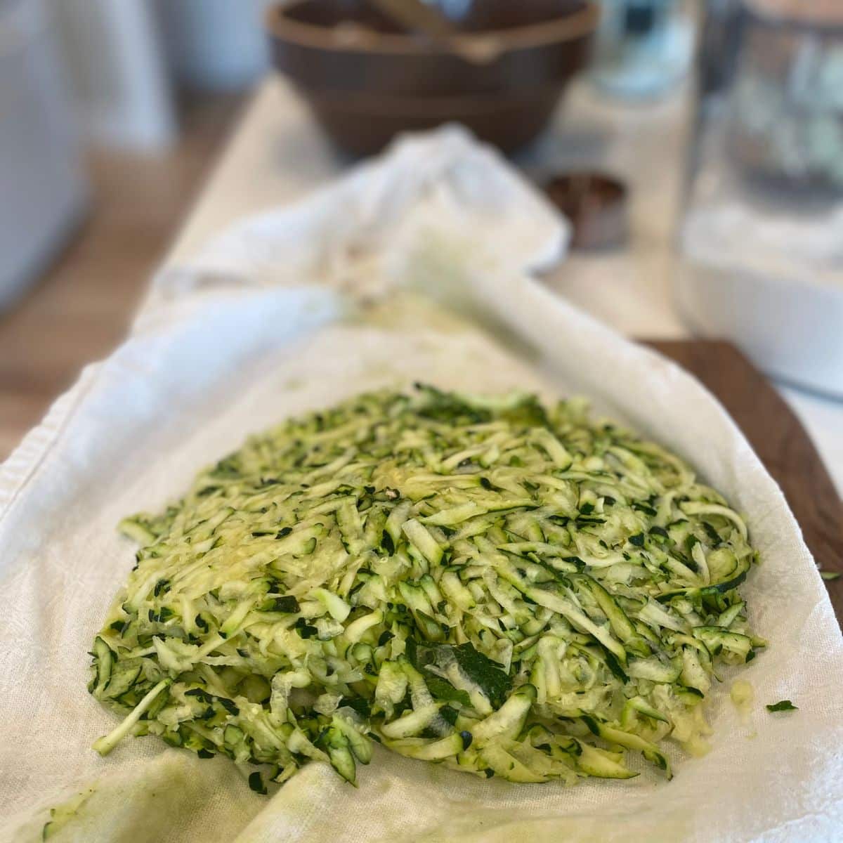 zucchini ofr sourdough zucchini muffins with water pressed out on a towel