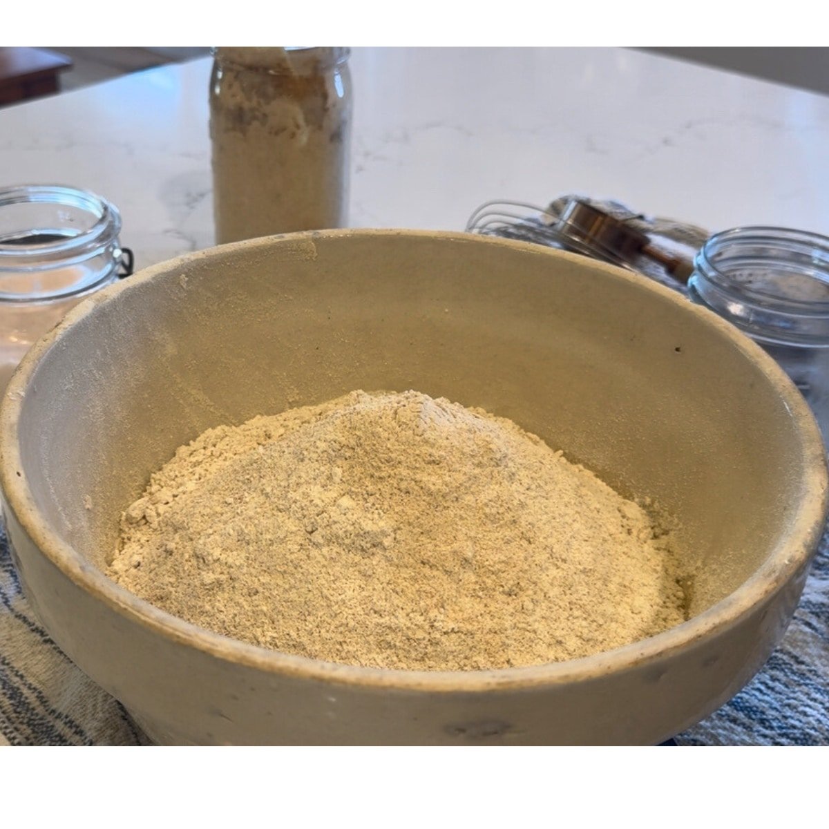 natural dough enhancer in the mixing bowl with bread ingredients flour, water, sourdough starter and salt