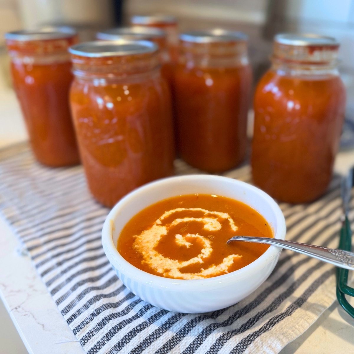homemade canned tomato soup in jars and served in a bowl