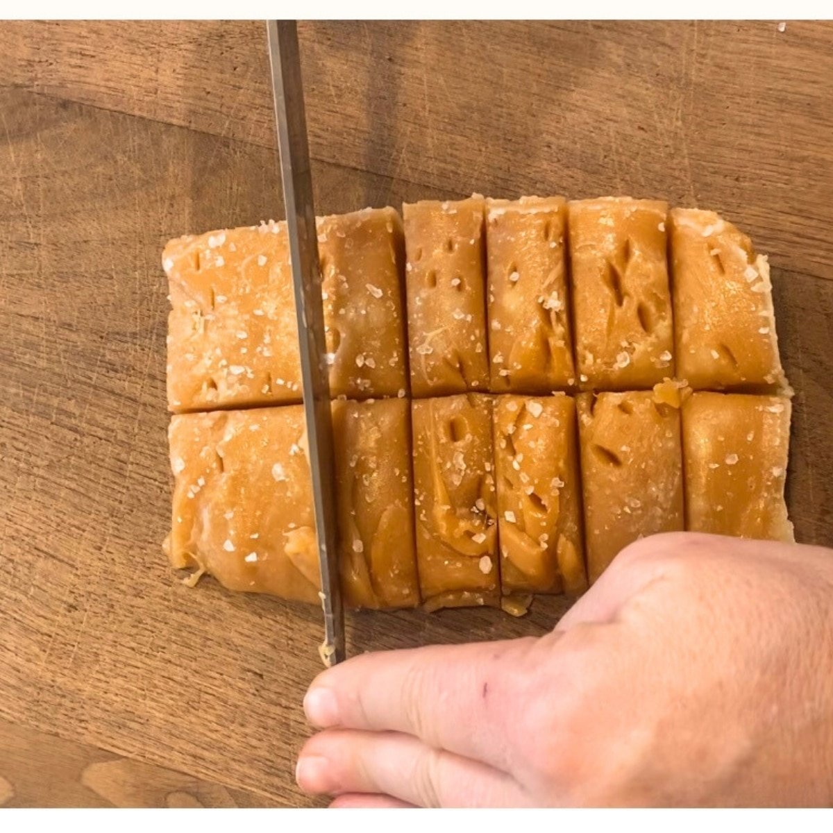 slicing salted caramels on cutting board