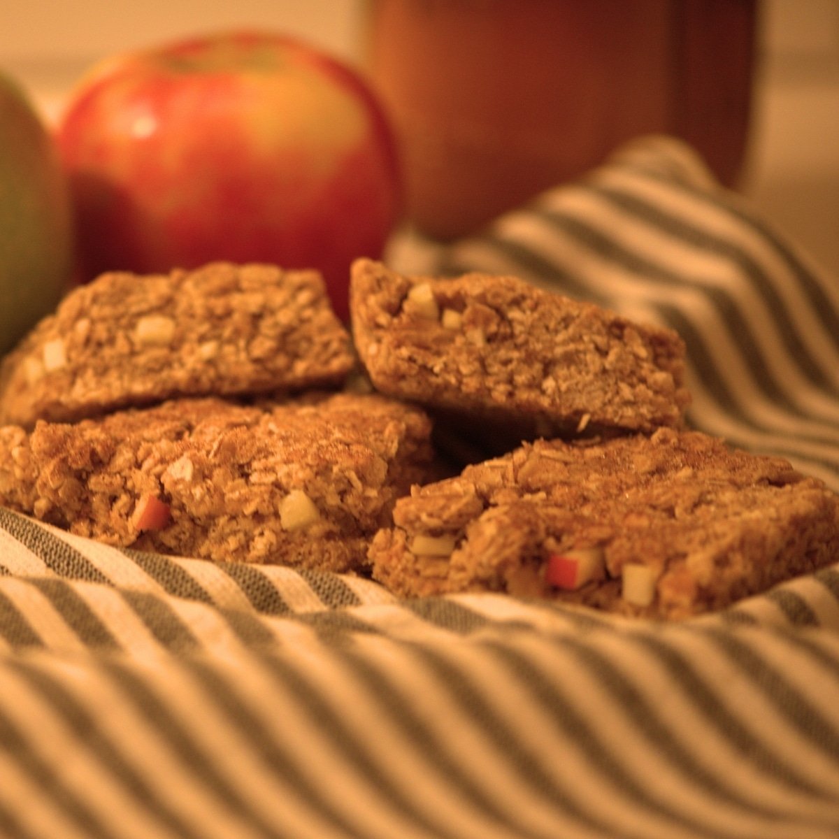 sliced sourdough apple breakfast bars on towel with apples in background