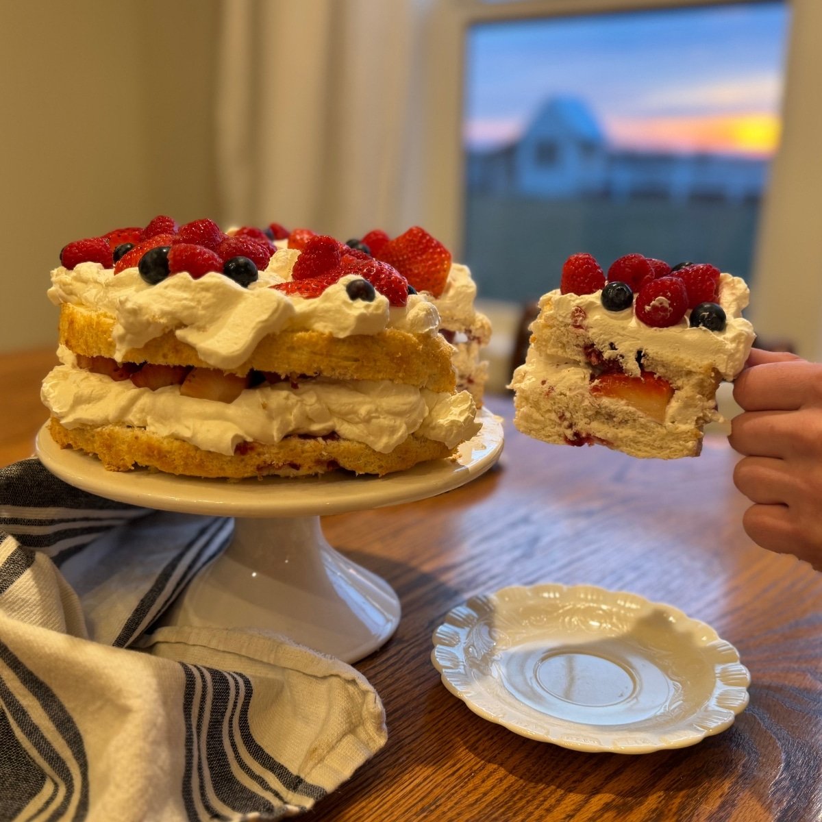 Sourdough Angel Food Cake with Raspberry Lemon Swirl slice being removed