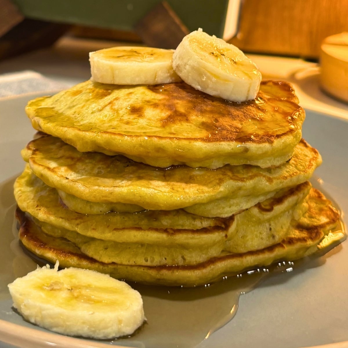 3 ingredient banana pancakes stacked with syrup and banana slices