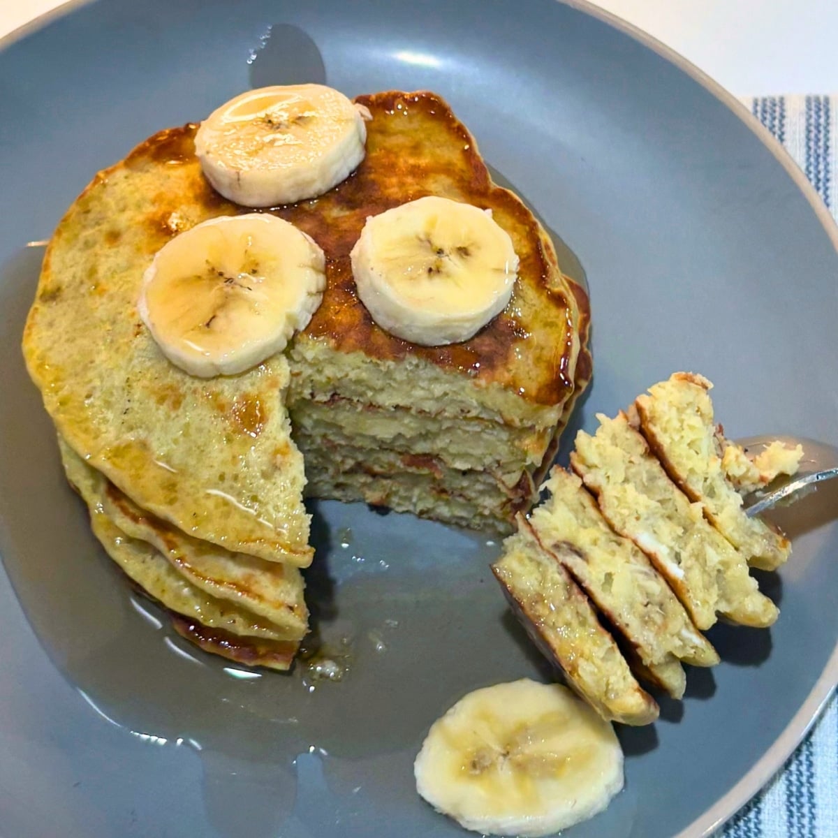 sliced ofrk full of stacked banan pancakes