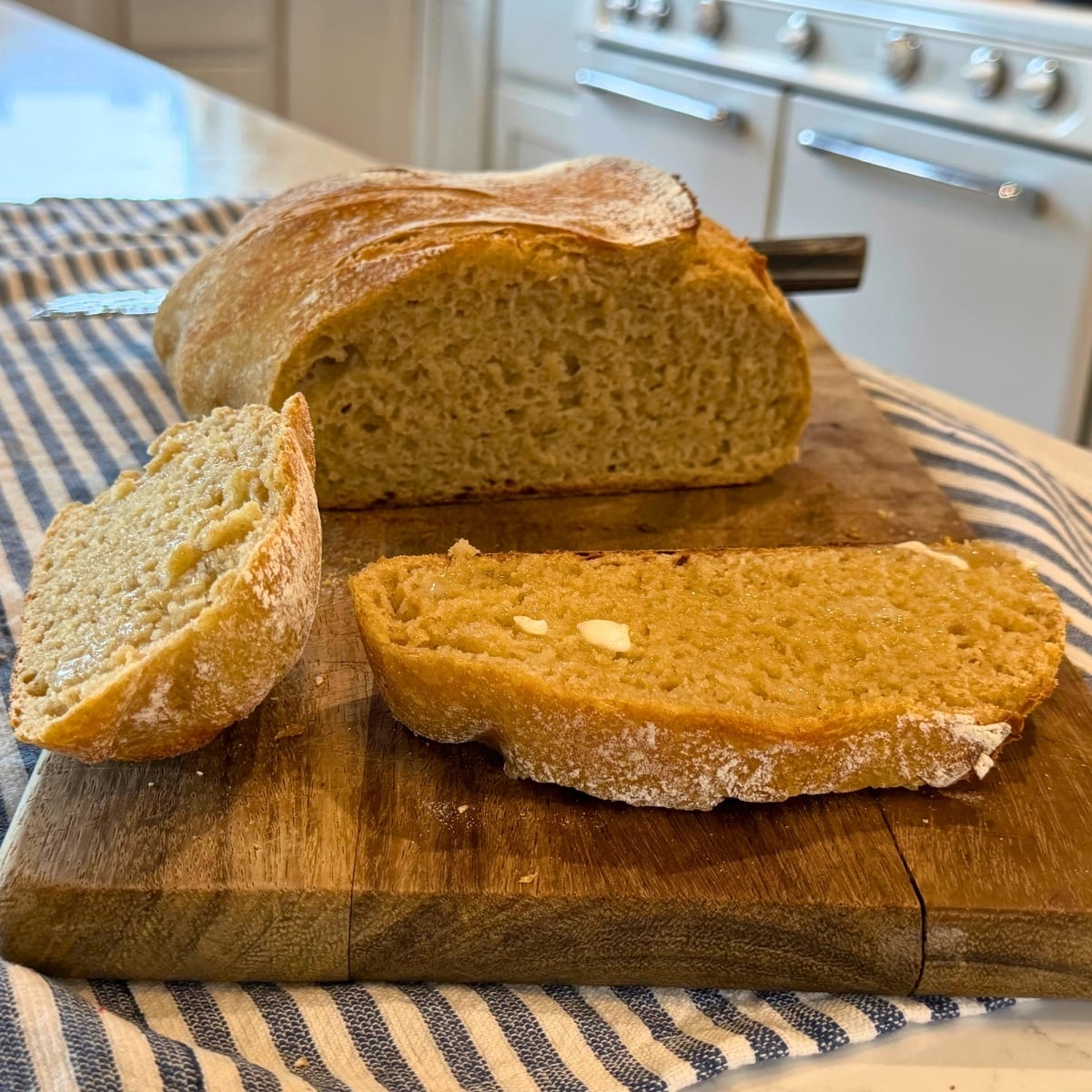 butter melting on sliced easy whole wheat sourdough bread recipe loaf cooling on cutting board