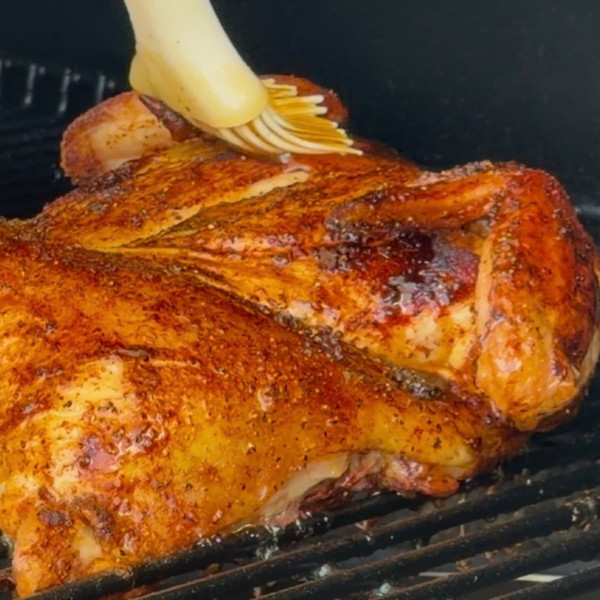 glazing spatchcocked chicken on grill