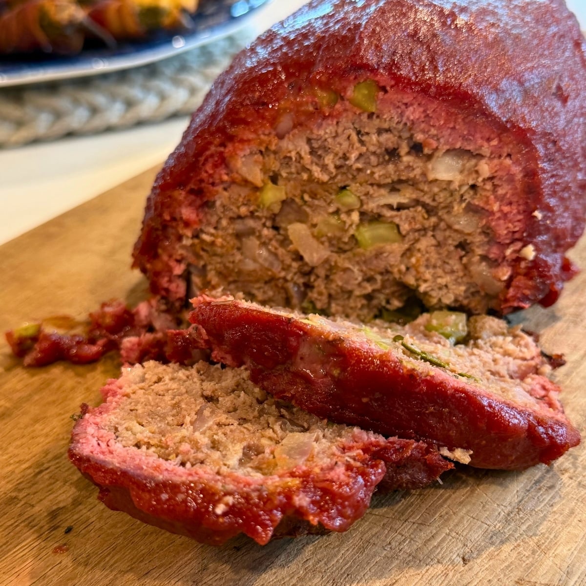 easy grilled meatloaf sliced showing inside veeggies and meattloaf in a kasup glaze