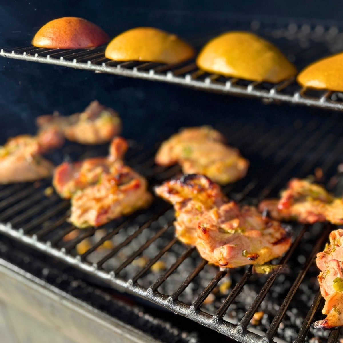 grilling chien theighs on grill with mangoes