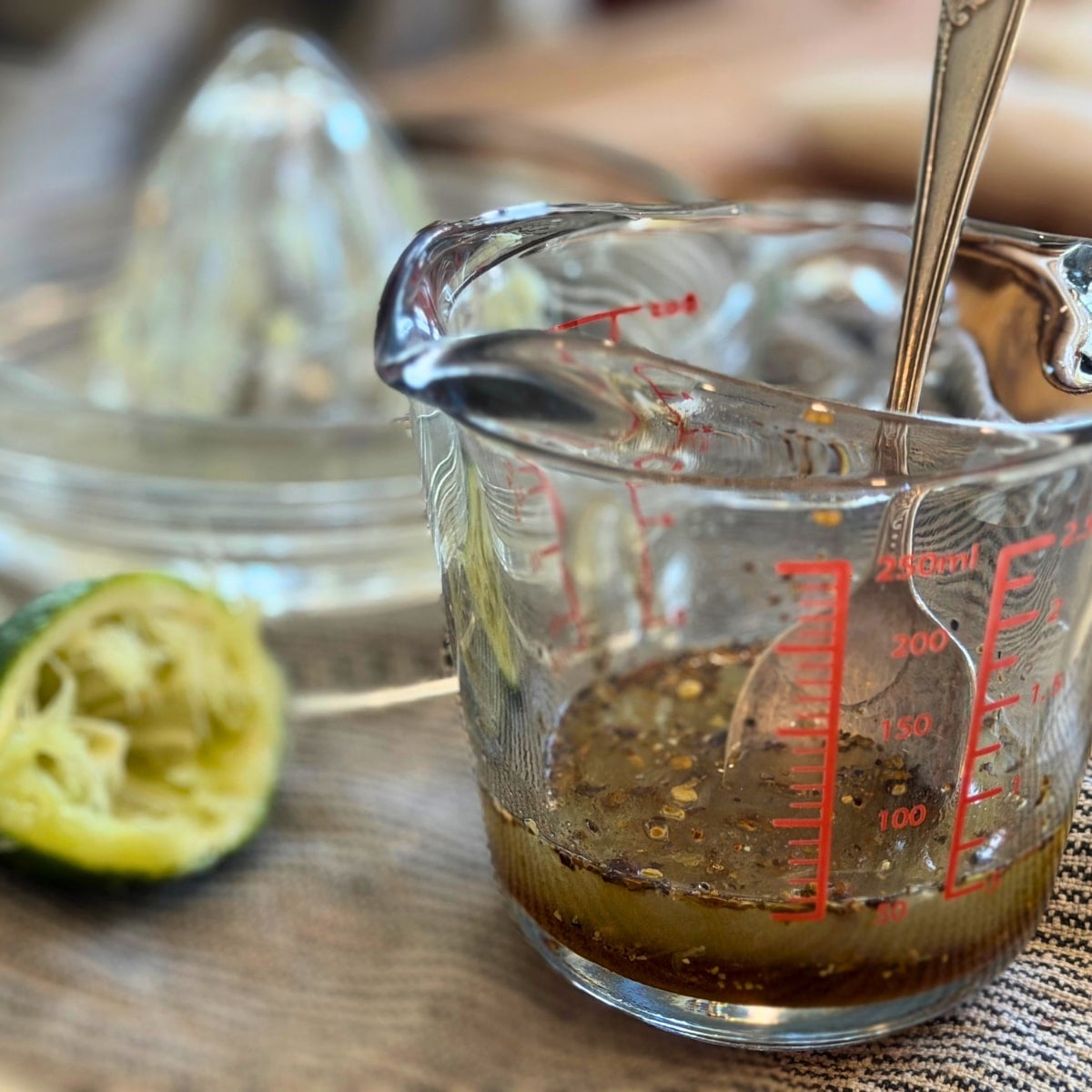 making honey lime glaze... juiced lime alond side a measuring cup with mine juice honey and hatch pepepr flakes in it