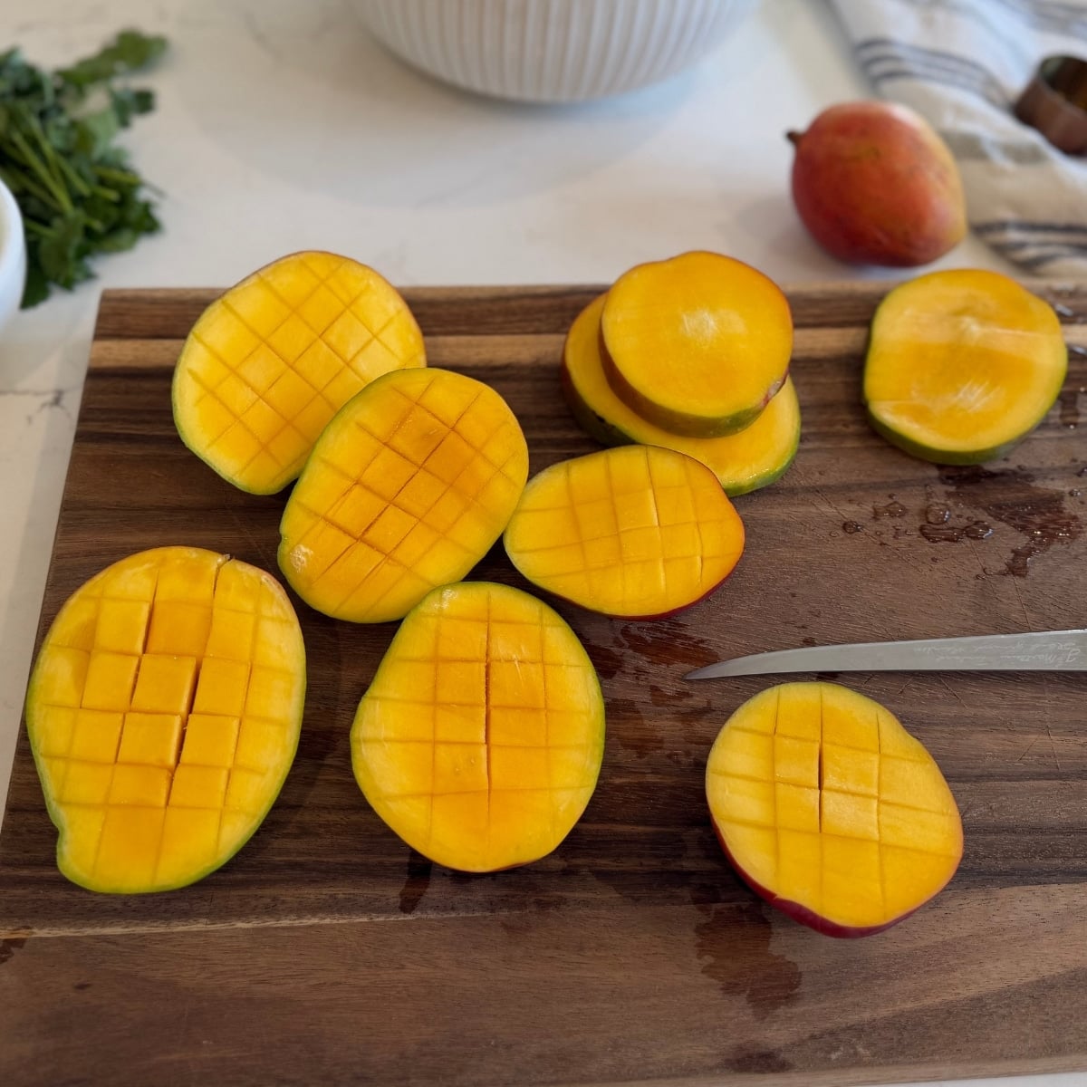 mangoes on a wood cutting board sliced and prepped for the grill