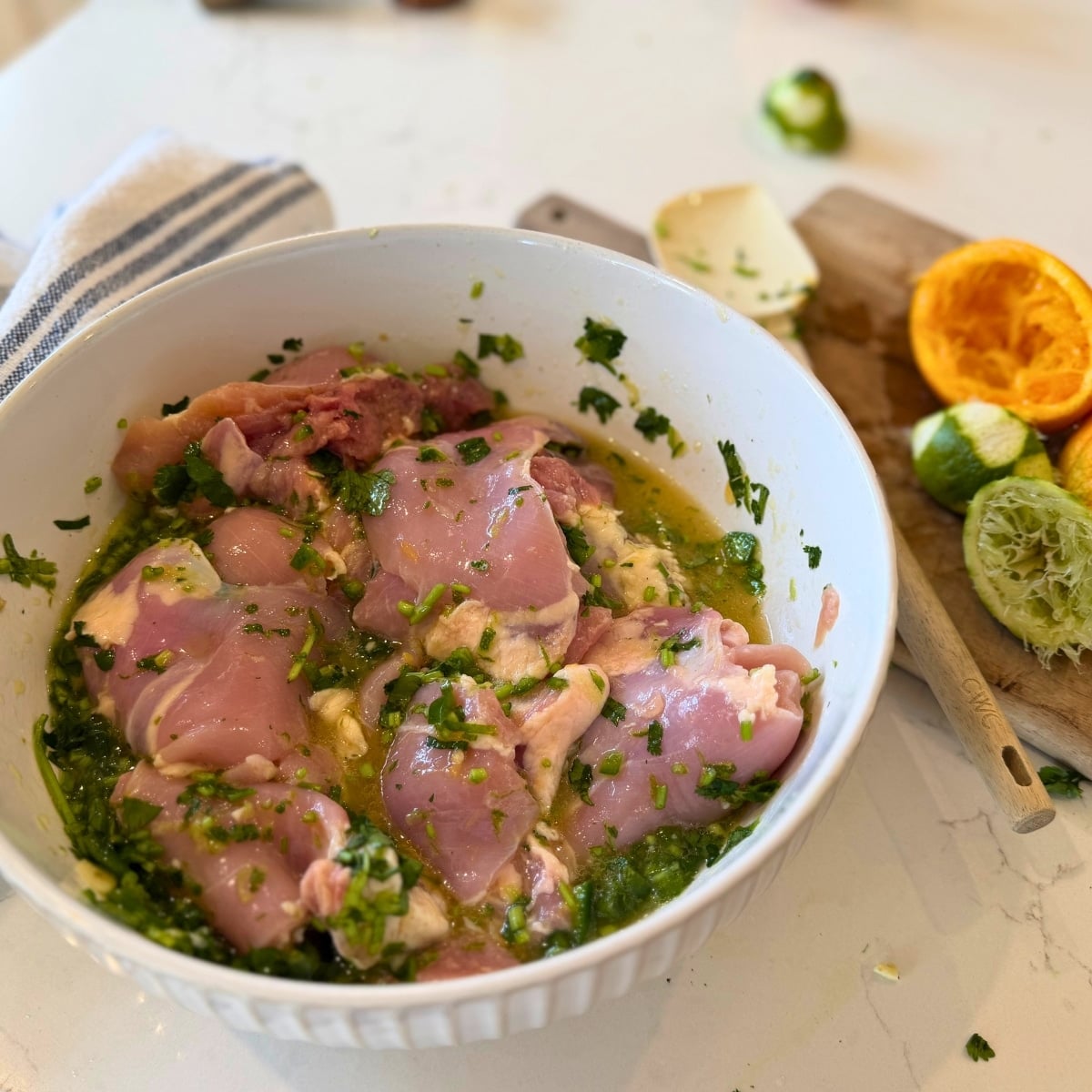 marinating chicken theighs in citrus marinade in a bowl