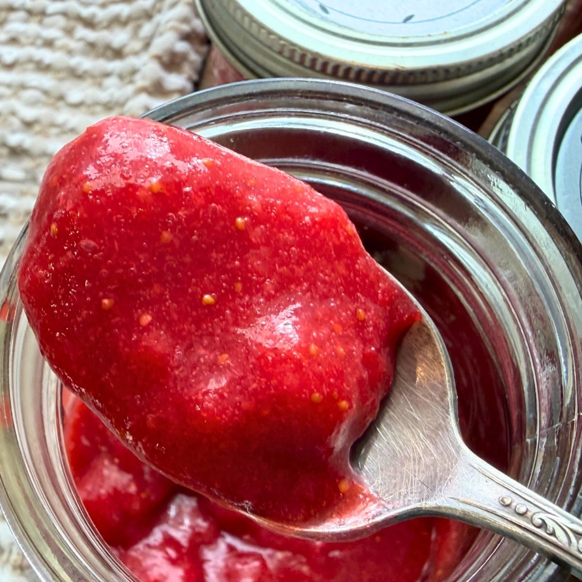 Strawberry Jam Canning Recipe - jar opened with spoonfull of canned strawberry jam