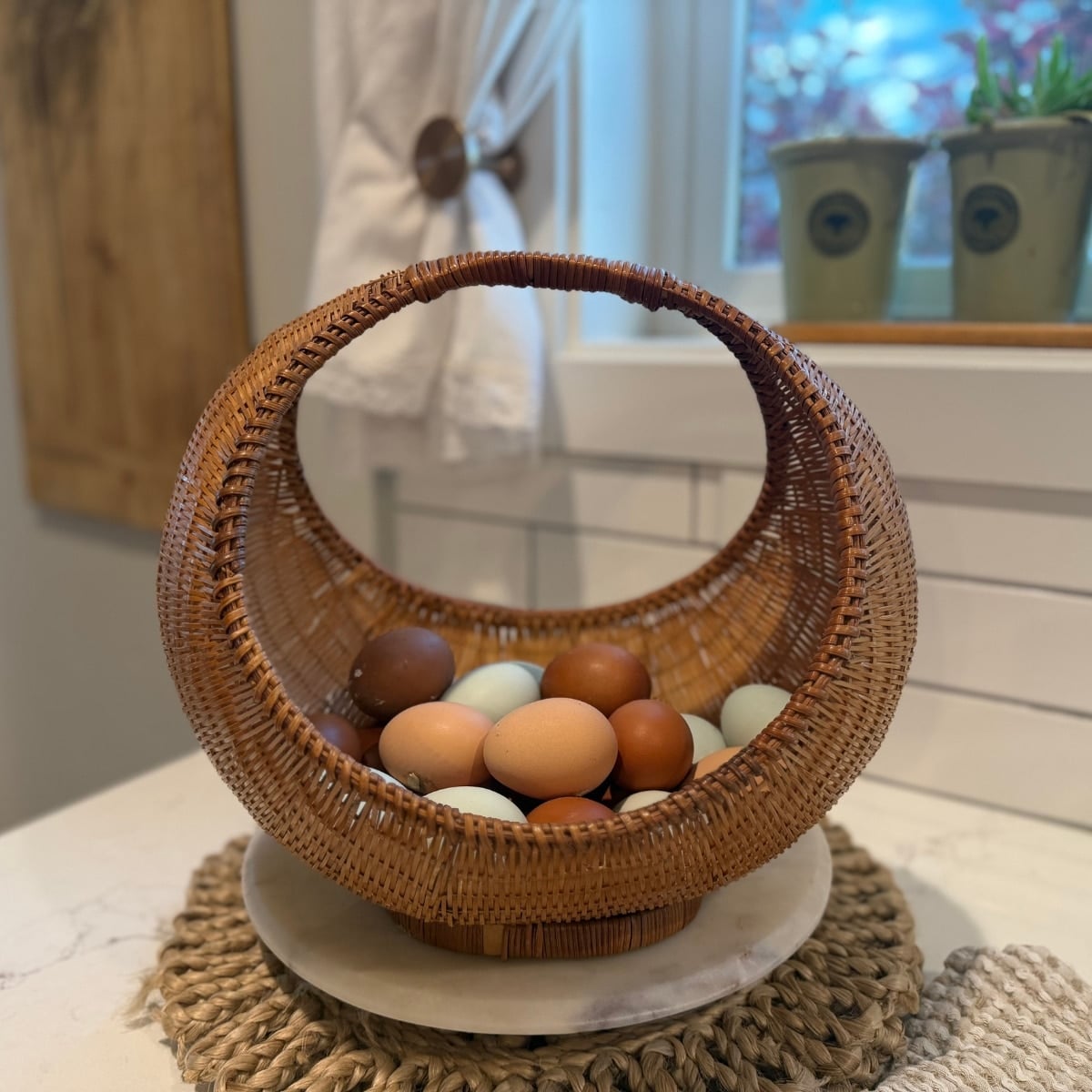 basket of fresh eggs sitting on the counter under the farmhouse kitchen window