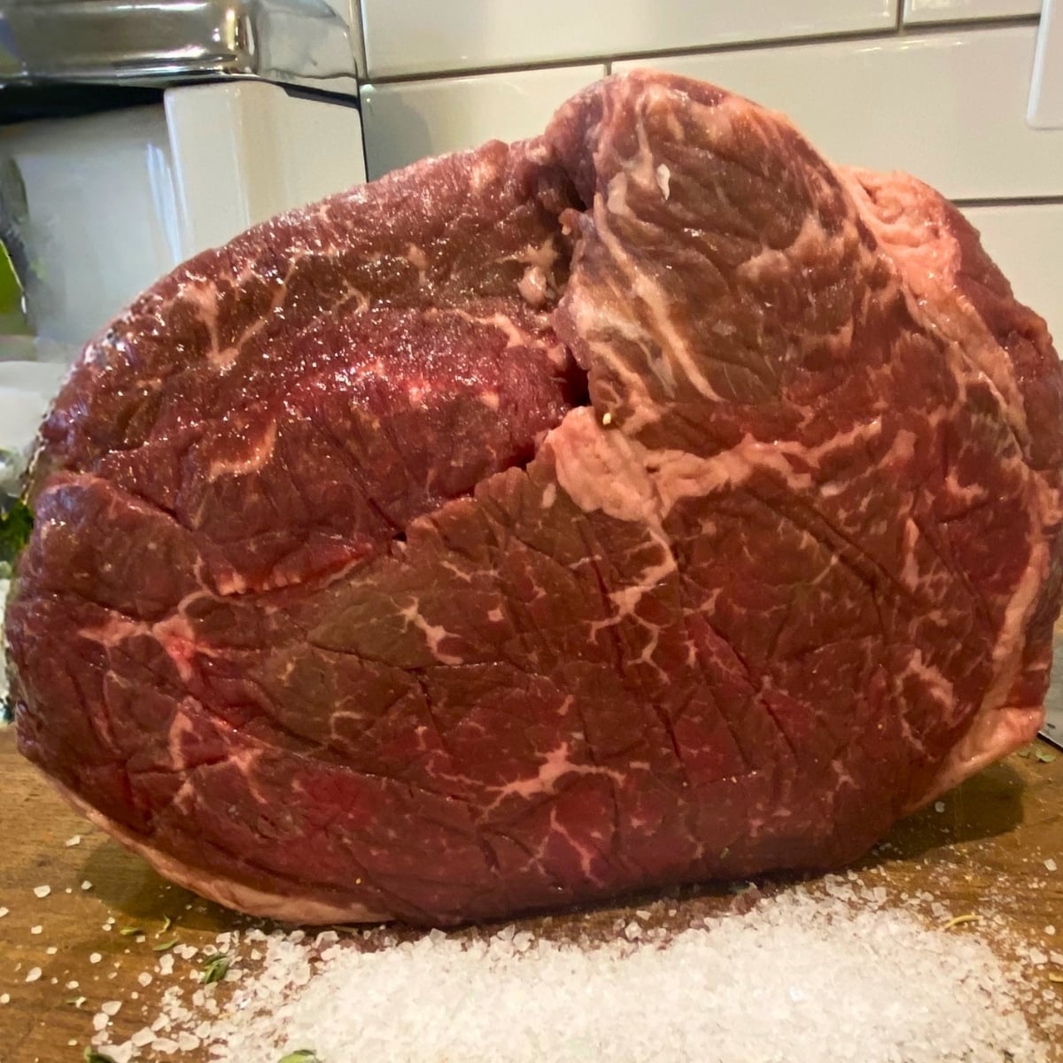 raw rump roast on cutting board with salt